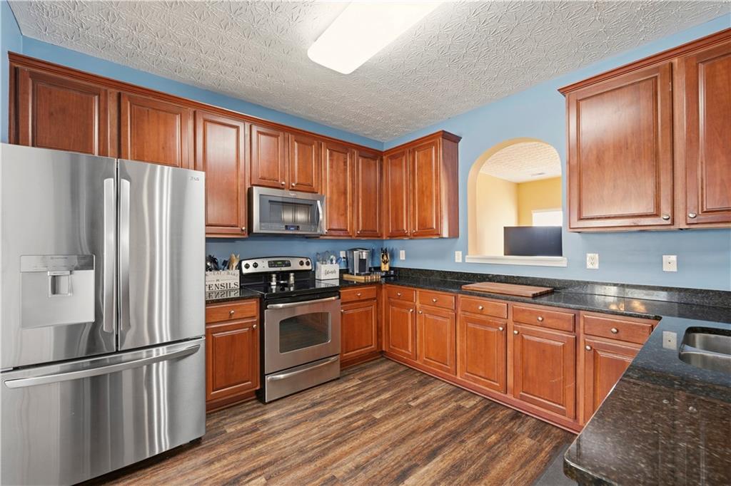 2708 Oakmont Way Monroe, GA 30656 - Photo 9 of 40 a kitchen with stainless steel appliances granite countertop a refrigerator stove microwave and sink