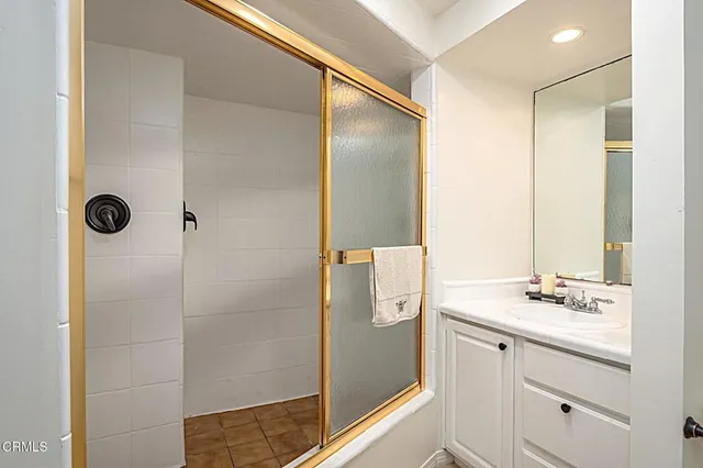 a bathroom with a shower sink and mirror