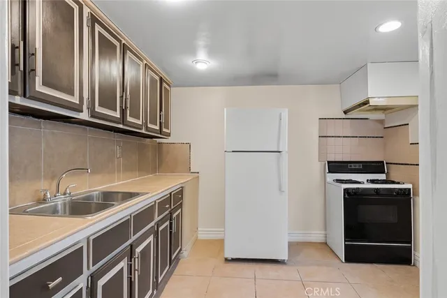 a kitchen with stainless steel appliances granite countertop a refrigerator a stove and a sink
