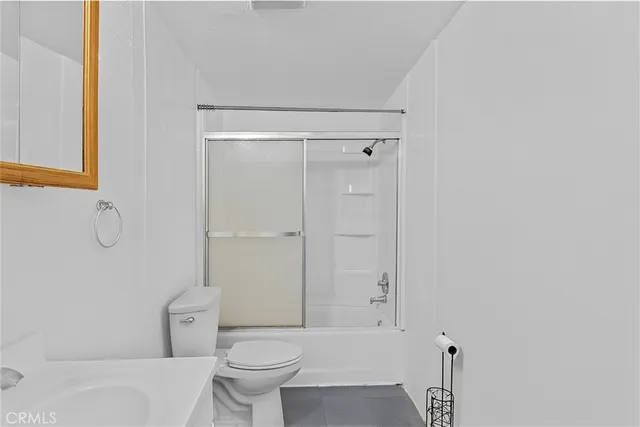 a bathroom with a granite countertop toilet a sink and a shower