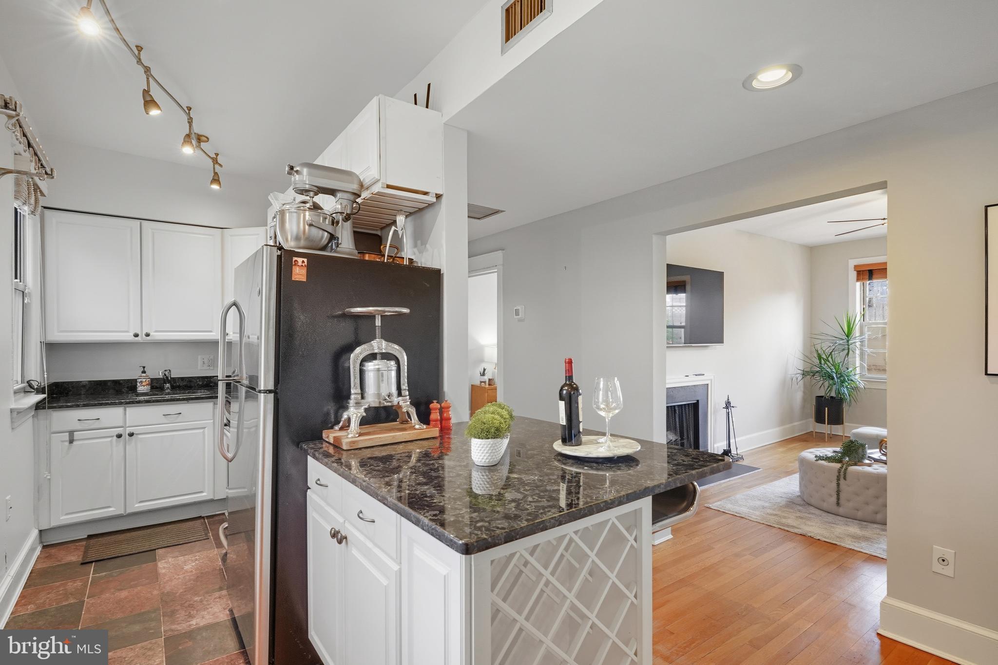 18 9th Street Northeast, Unit 302 Washington, DC 20002 - Photo 12 of 38 a kitchen with kitchen island granite countertop a sink stove and cabinets