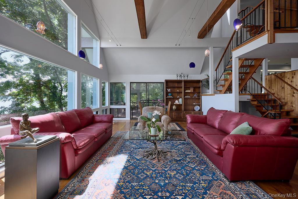 273 River Road Nyack, NY 10960 - Photo 4 of 48 Living room featuring extensive window walls, exposed wood ceiling beams, and wood-finish flooring