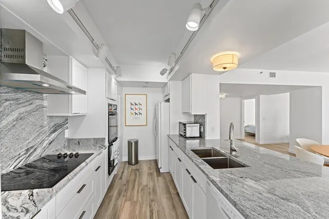 a kitchen with stainless steel appliances granite countertop a sink stove and cabinets