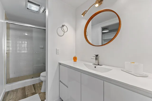 a bathroom with a sink mirror vanity and toilet
