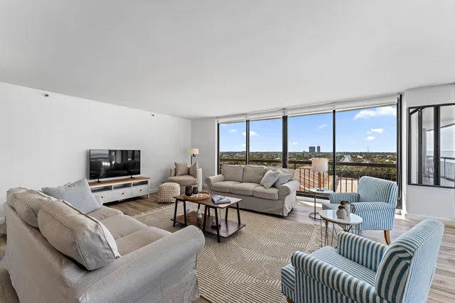 a living room with furniture and floor to ceiling windows