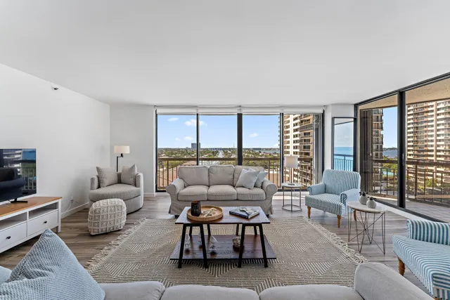 a living room with furniture and a large window with balcony view
