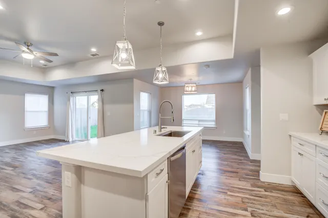 a large kitchen with granite countertop a stove and a wooden floors