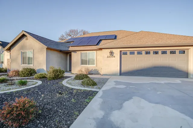 a view of a house with a yard and potted plants