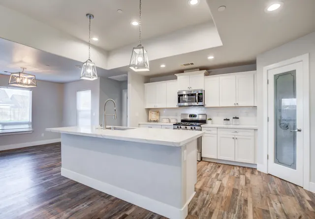 a kitchen with kitchen island a sink stainless steel appliances and cabinets