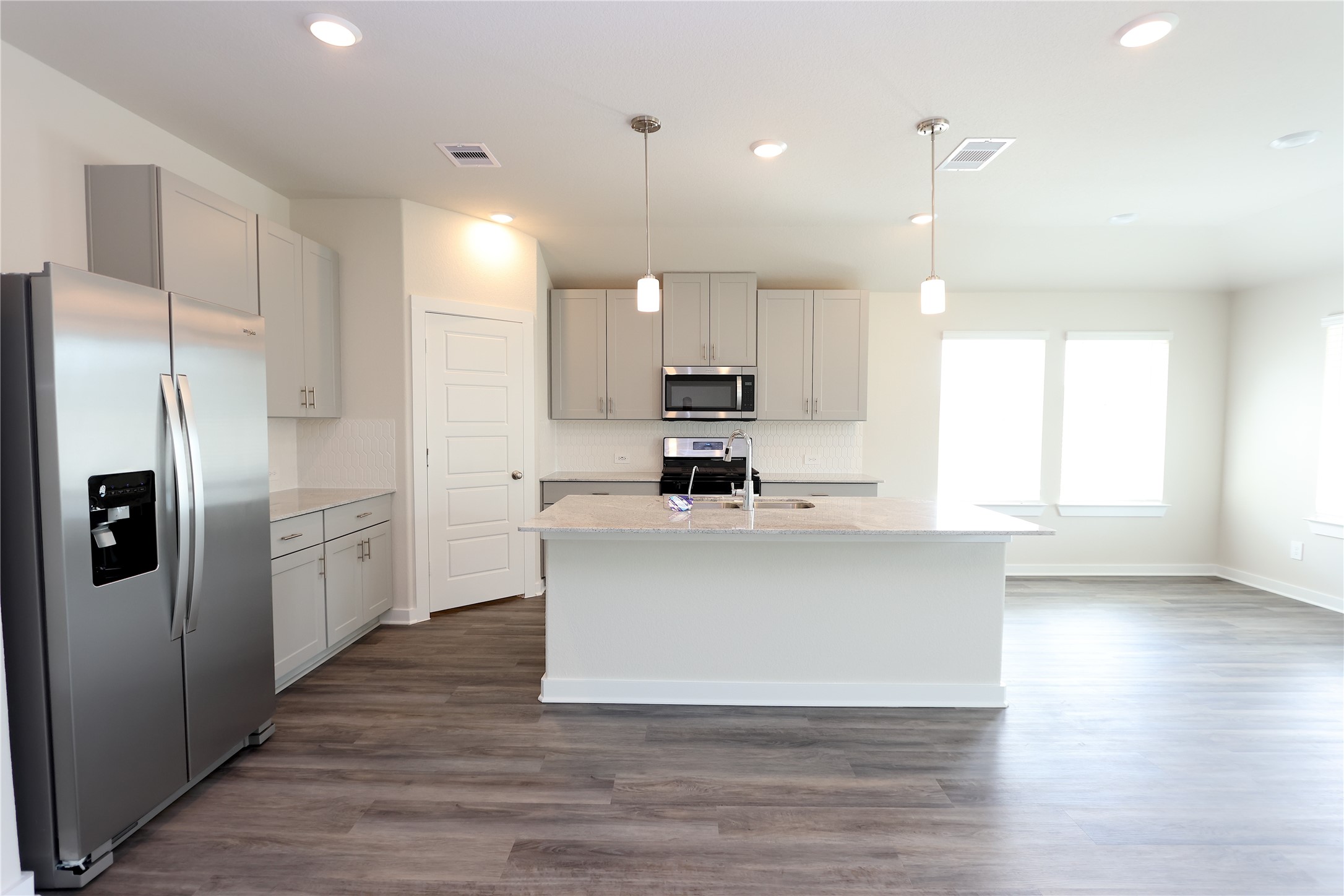 1480 Waggoner Rnch Trail Conroe, TX 77301 - Photo 11 of 18 a kitchen with stainless steel appliances granite countertop a refrigerator a sink a stove and white cabinets with wooden floor