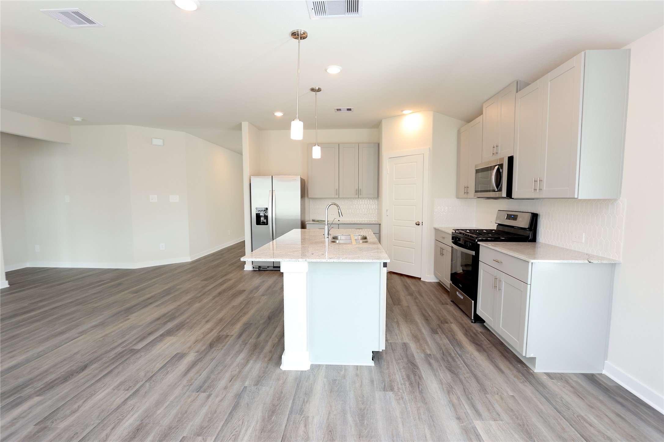 1480 Waggoner Rnch Trail Conroe, TX 77301 - Photo 12 of 18 a kitchen with a sink wooden floor and stainless steel appliances