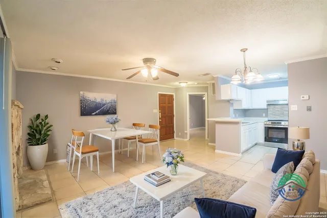 a living room with furniture kitchen view and a chandelier
