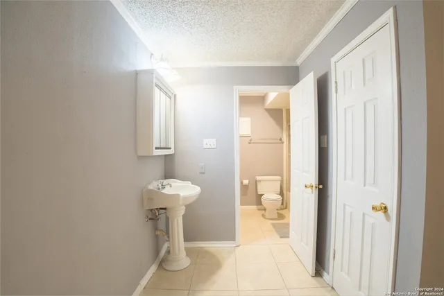 a bathroom with a sink toilet and a mirror