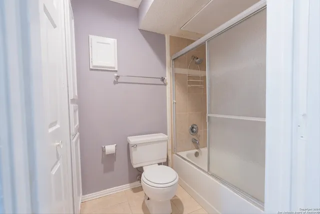 a white toilet sitting next to a bathroom sink and a shower