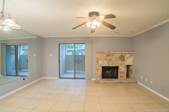 an empty room with fireplace and fan