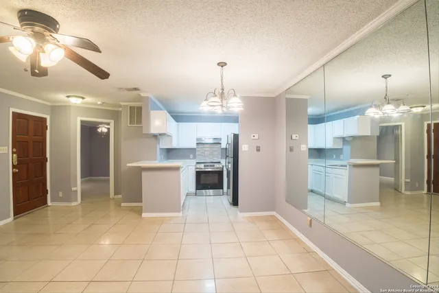 a large kitchen with stainless steel appliances kitchen island granite countertop a refrigerator and a sink