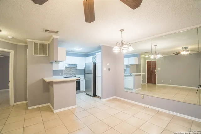 a view of a kitchen with kitchen island granite countertop a refrigerator and a sink