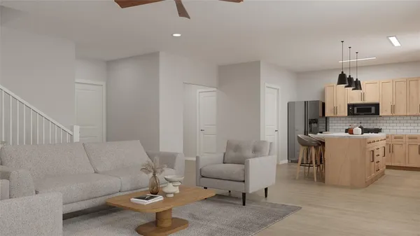 a living room with furniture and a kitchen view