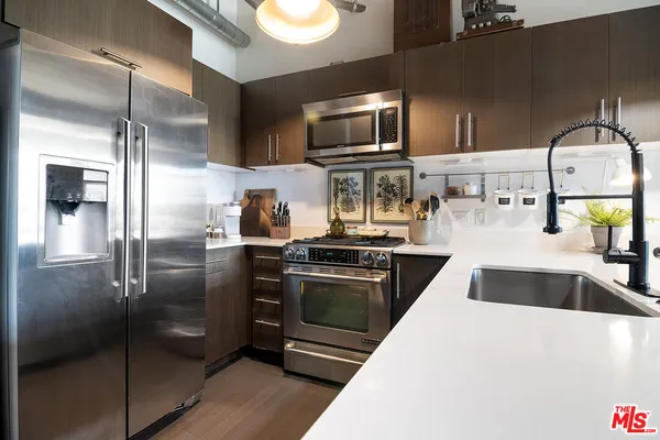a kitchen with granite countertop a refrigerator and a sink