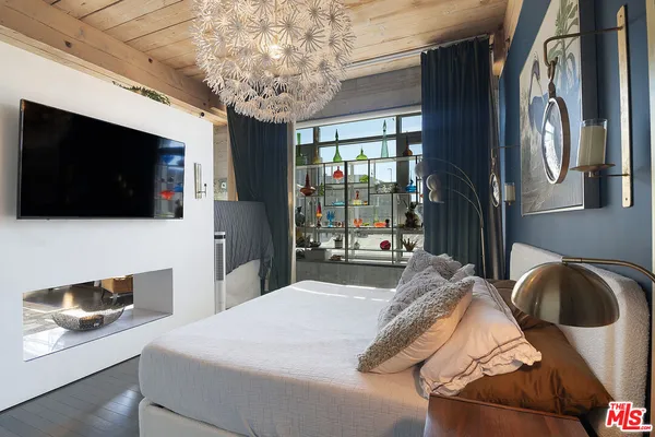 a bedroom with a large bed and a flat screen tv