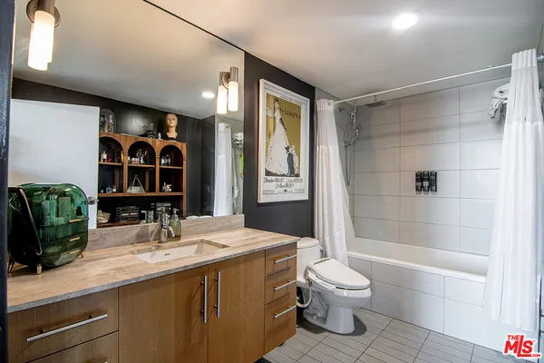 a bathroom with a double vanity sink toilet mirror and shower