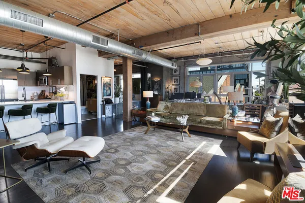 a living room with lots of furniture and kitchen view