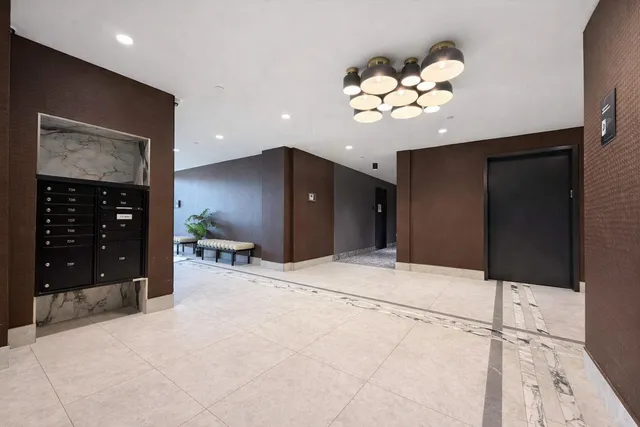 a large white kitchen with a refrigerator and a chandelier