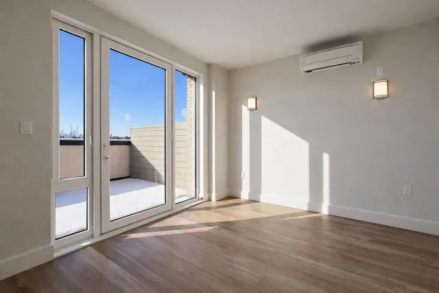 a view of a big room with wooden floor and windows