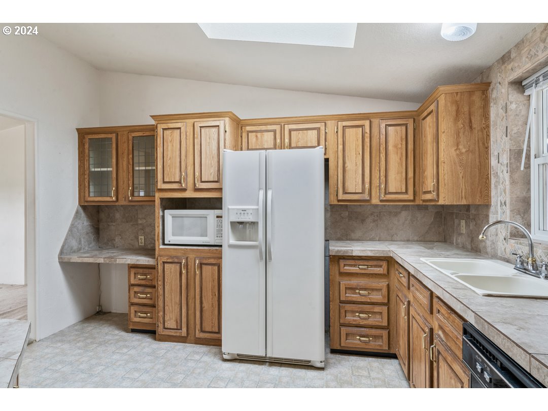 2150 Laura Street, Unit 212 Springfield, OR 97477 - Photo 12 of 37 a kitchen with stainless steel appliances granite countertop a refrigerator and a sink