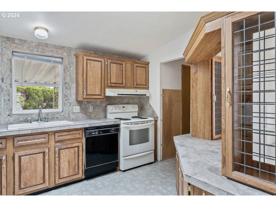 2150 Laura Street, Unit 212 Springfield, OR 97477 - Photo 13 of 37 a kitchen with stainless steel appliances granite countertop a stove a sink and a refrigerator