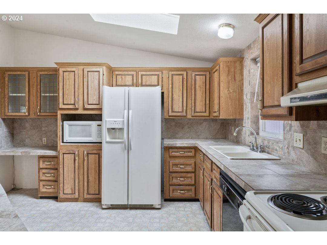 2150 Laura Street, Unit 212 Springfield, OR 97477 - Photo 14 of 37 a kitchen with stainless steel appliances granite countertop a refrigerator stove and sink