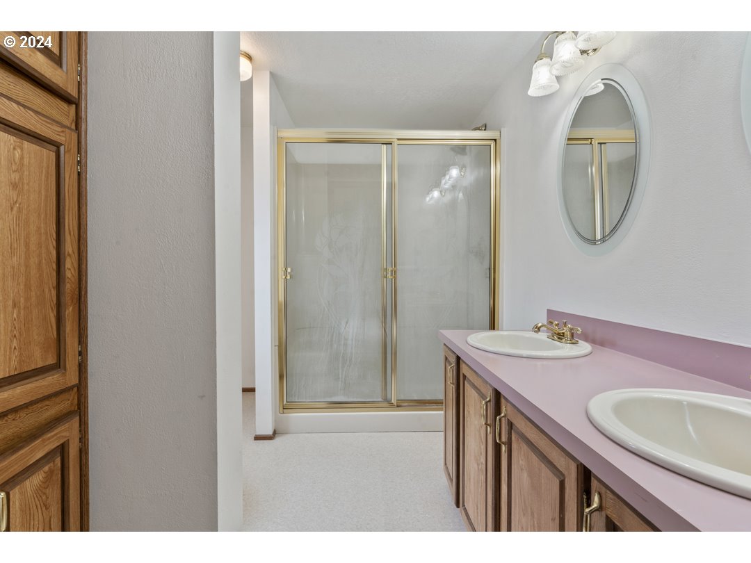 2150 Laura Street, Unit 212 Springfield, OR 97477 - Photo 23 of 37 a bathroom with a sink a mirror a vanity and a shower