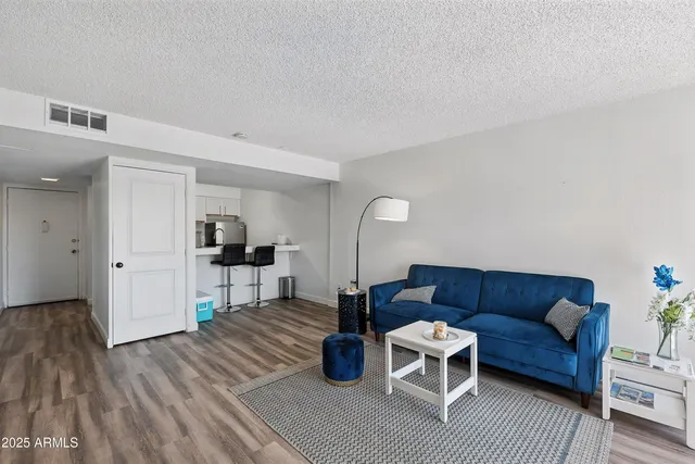 a living room with furniture and a wooden floor