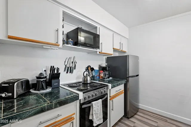 a kitchen with granite countertop a stove and a microwave