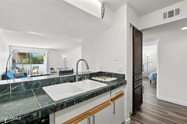 a kitchen with a granite countertop sink stove and cabinets