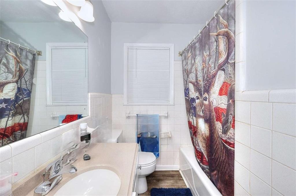 4455 Jersey Walnut Grove Road Covington, GA 30014 - Photo 17 of 28 a bathroom with a sink a toilet and shower curtain