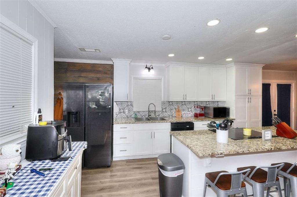 4455 Jersey Walnut Grove Road Covington, GA 30014 - Photo 9 of 28 a kitchen with granite countertop kitchen island stainless steel appliances a sink and a refrigerator