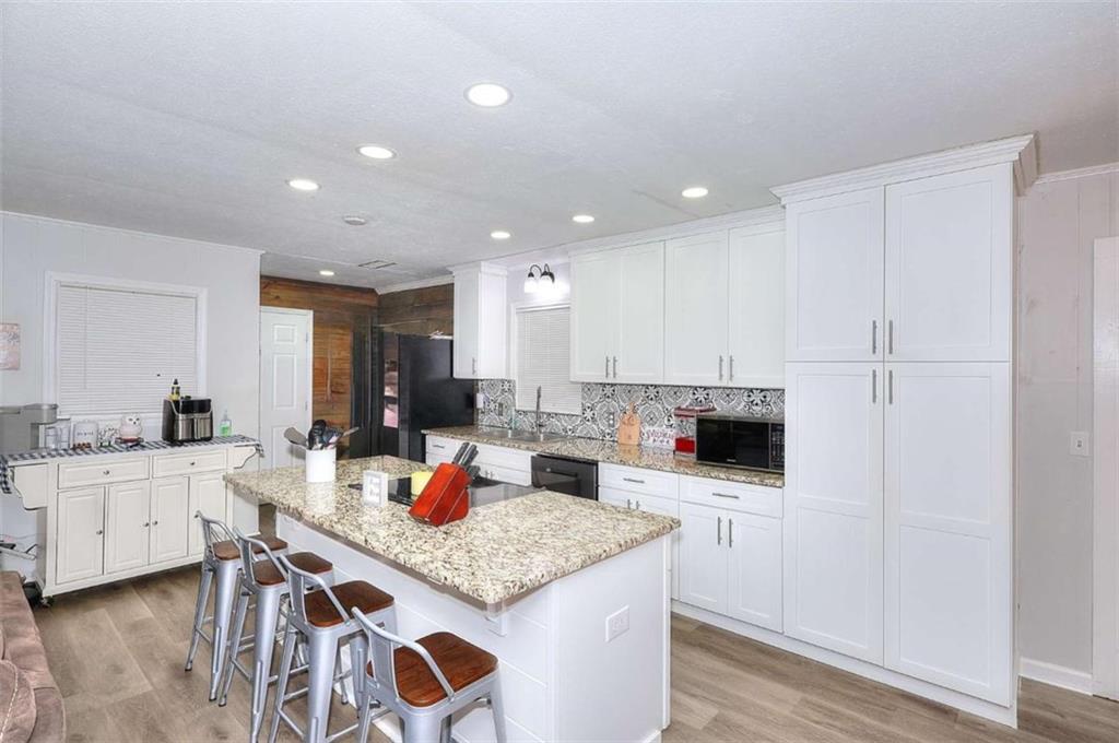 4455 Jersey Walnut Grove Road Covington, GA 30014 - Photo 10 of 28 a kitchen with stainless steel appliances kitchen island granite countertop a sink and cabinets