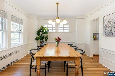 a dining room with furniture potted plants and wooden floor