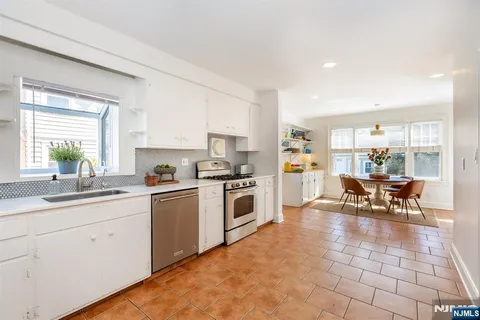 a kitchen with a white cabinets and chairs in it