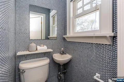 a bathroom with a sink toilet and mirror