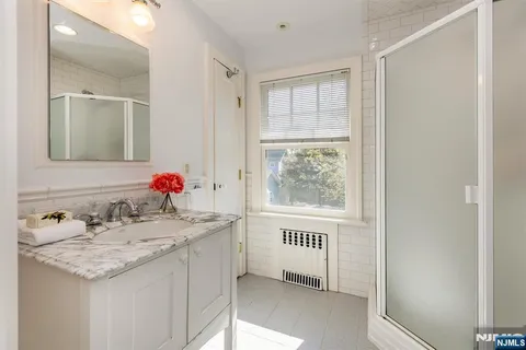 a bathroom with a granite countertop sink and a window