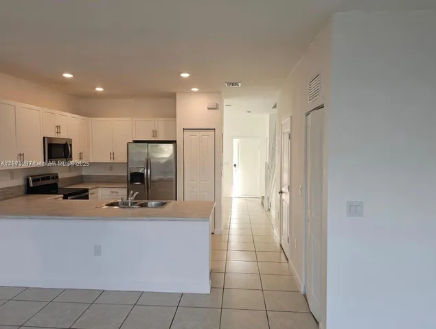 a kitchen with stainless steel appliances a refrigerator sink and microwave