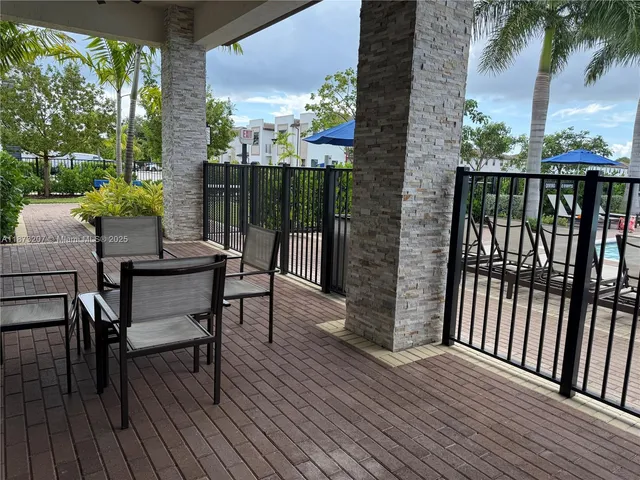 a living room with furniture a chandelier and a potted plant