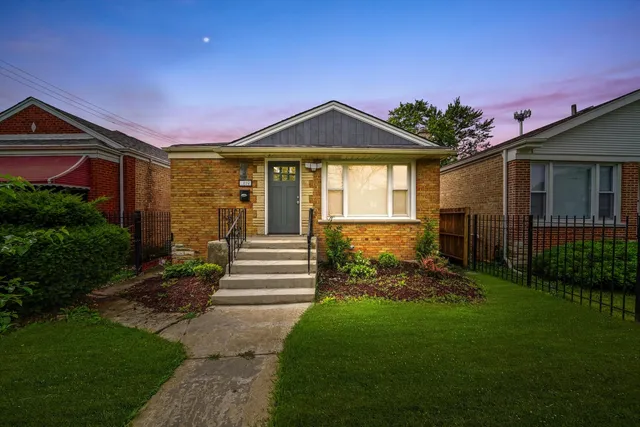 a front view of a house with a yard and potted plants