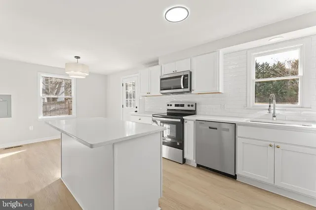 a kitchen with sink a microwave and white appliances