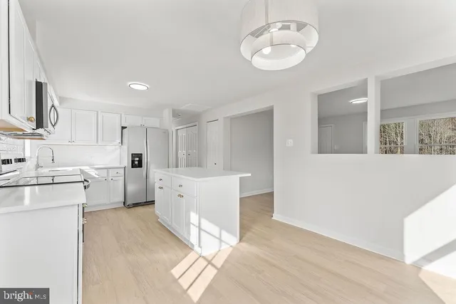 a kitchen with white cabinets and white appliances