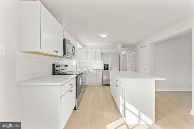 a kitchen with white cabinets appliances and sink