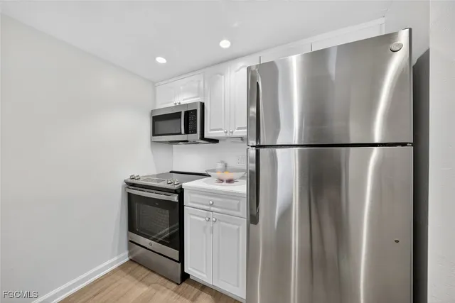 a kitchen with stainless steel appliances a refrigerator sink and microwave
