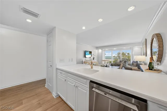a view of a kitchen with a sink and wooden floor